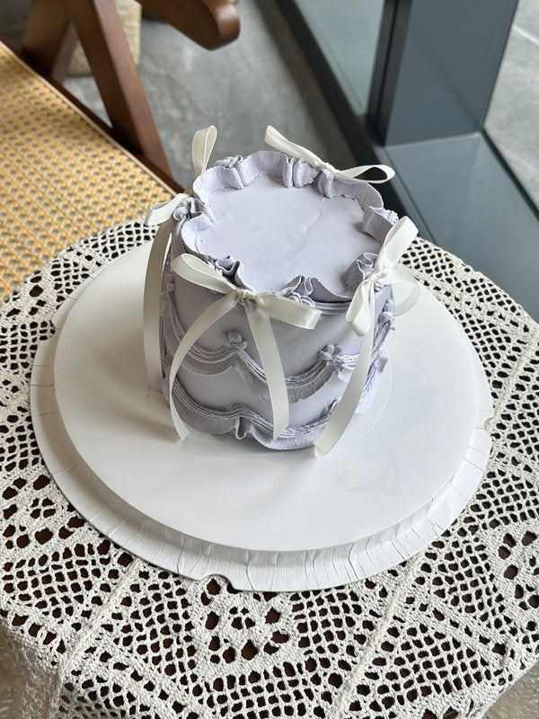 Light purple cake decorated with silk bow